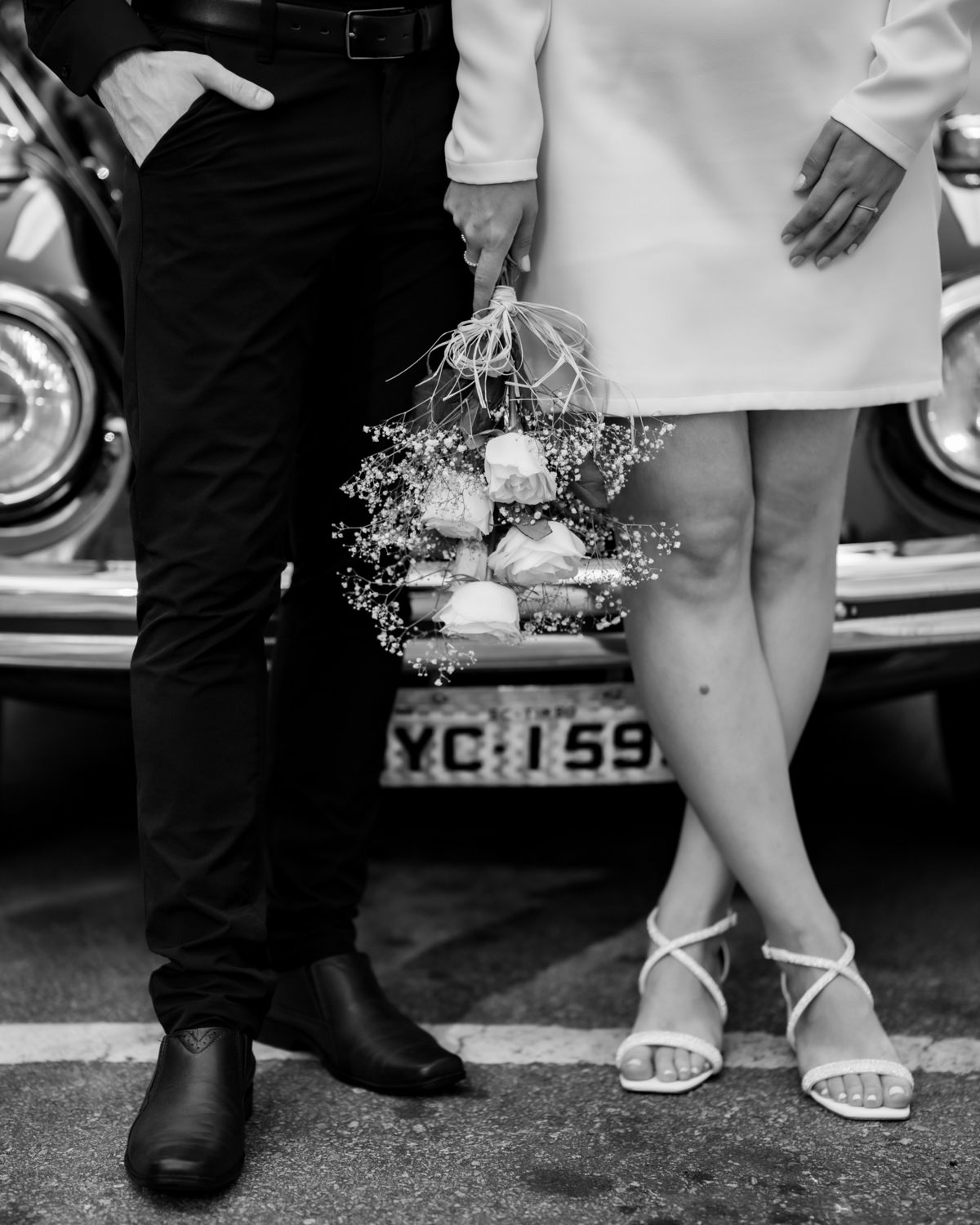 Ensaio pré-wedding ao pôr do sol na praia de Balneário Camboriú com skyline urbano ao fundo, casal brindando com champagne, estilo contemporâneo, romântico e espontâneo, fotografia profissional de casamento