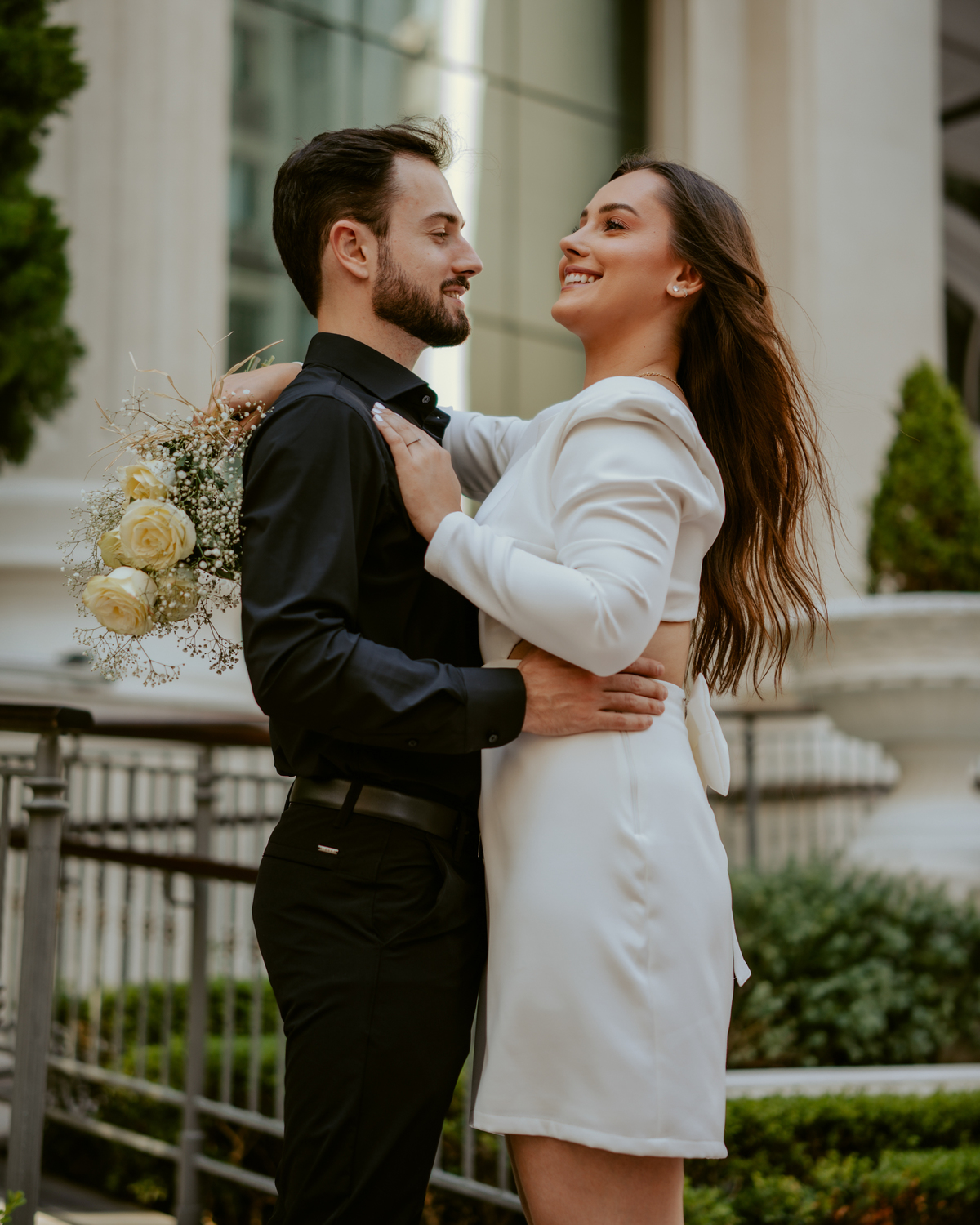 Casal em ensaio pré-wedding urbano elegante com Fusca clássico em Balneário Camboriú, cenário com fachada imponente, estilo contemporâneo e romântico, fotografia profissional com luz natural e composição sofisticada