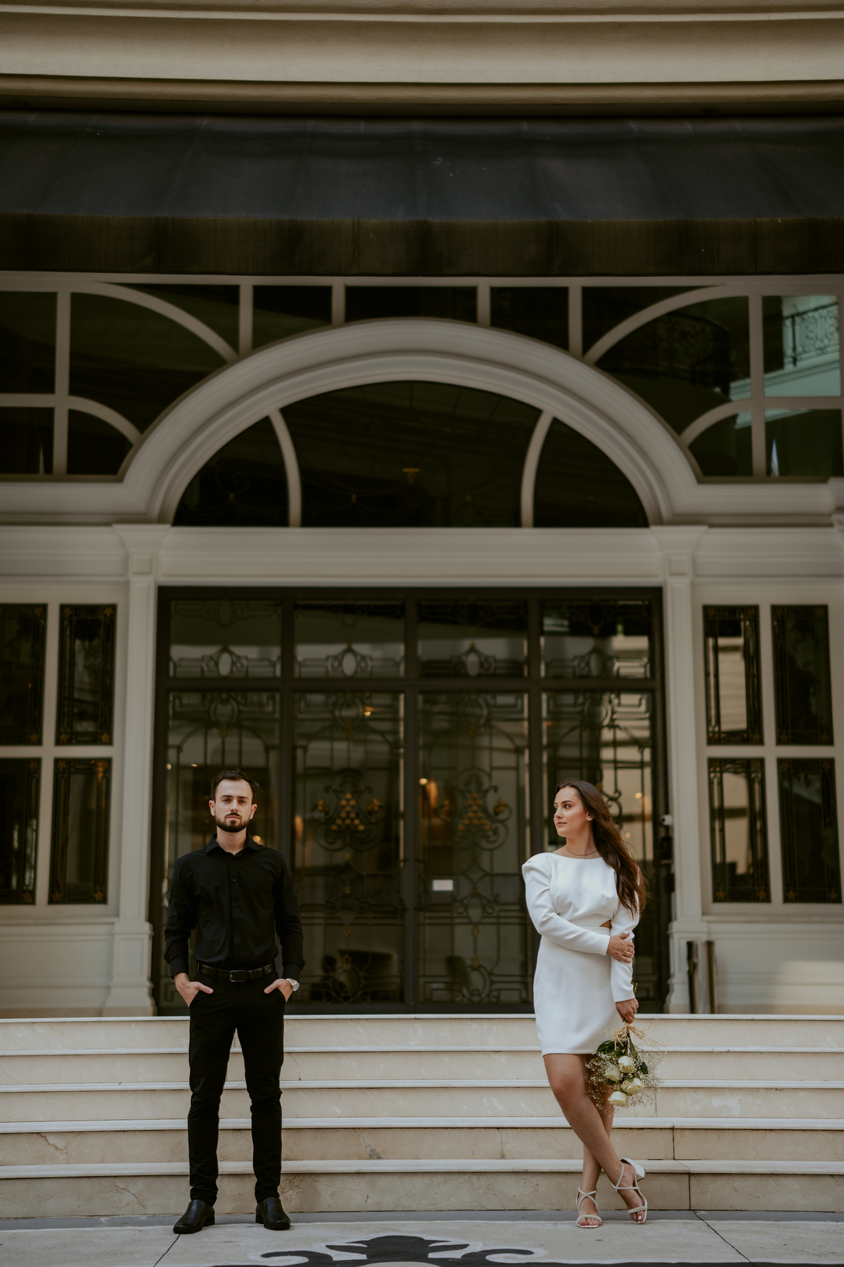 Casal em ensaio pré-wedding urbano elegante com Fusca clássico em Balneário Camboriú, cenário com fachada imponente, estilo contemporâneo e romântico, fotografia profissional com luz natural e composição sofisticada