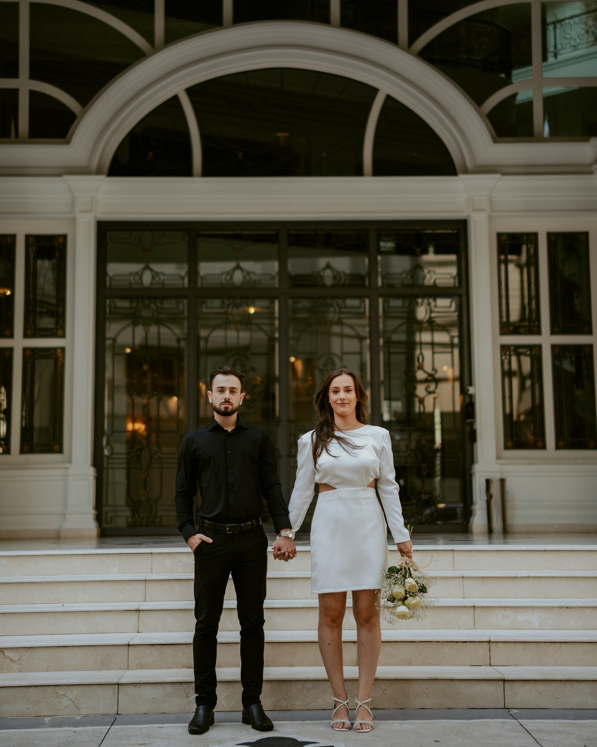 Casal em ensaio pré-wedding urbano elegante com Fusca clássico em Balneário Camboriú, cenário com fachada imponente, estilo contemporâneo e romântico, fotografia profissional com luz natural e composição sofisticada