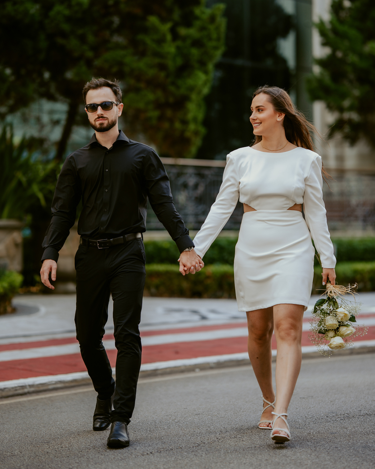 Casal apaixonado em ensaio pré-wedding com arquitetura clássica ao fundo em Balneário Camboriú, composição elegante, roupas sofisticadas preto e branco, fotografia emocional e moderna para casamento