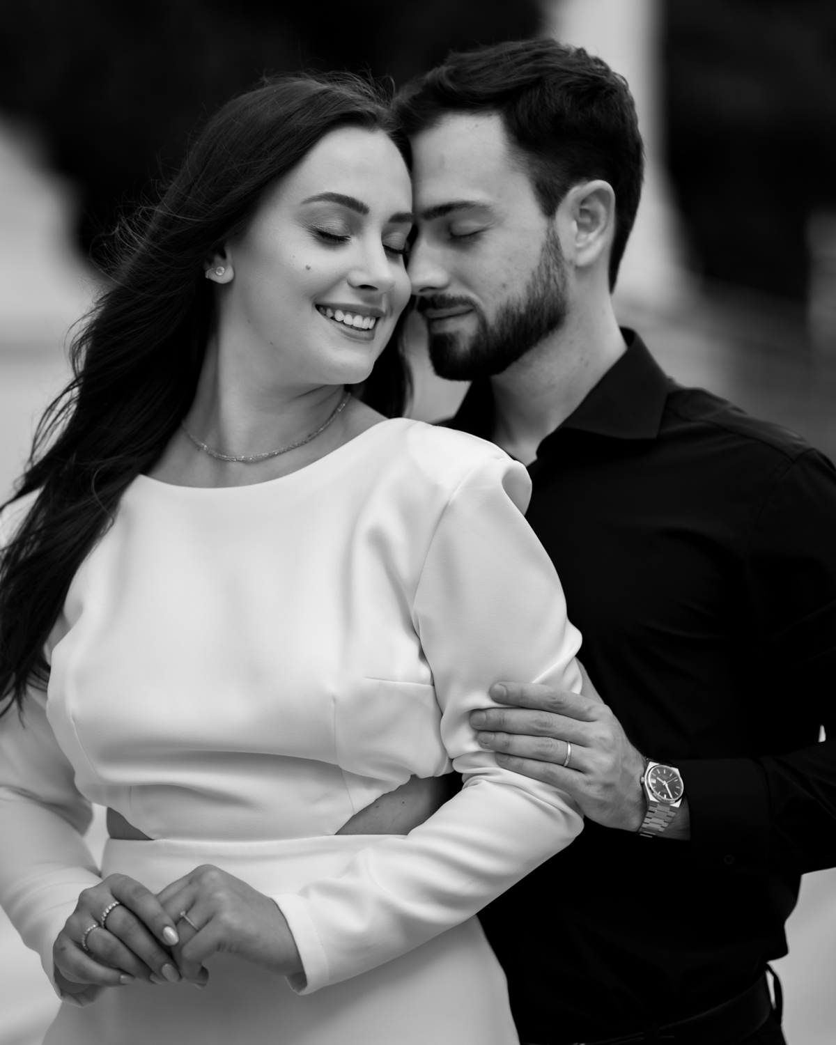 Ensaio pré-wedding na orla de Balneário Camboriú com pôr do sol entre prédios, casal sorrindo com champagne, estilo moderno e divertido, fotografia romântica com luz dourada e cenário urbano contemporâneo