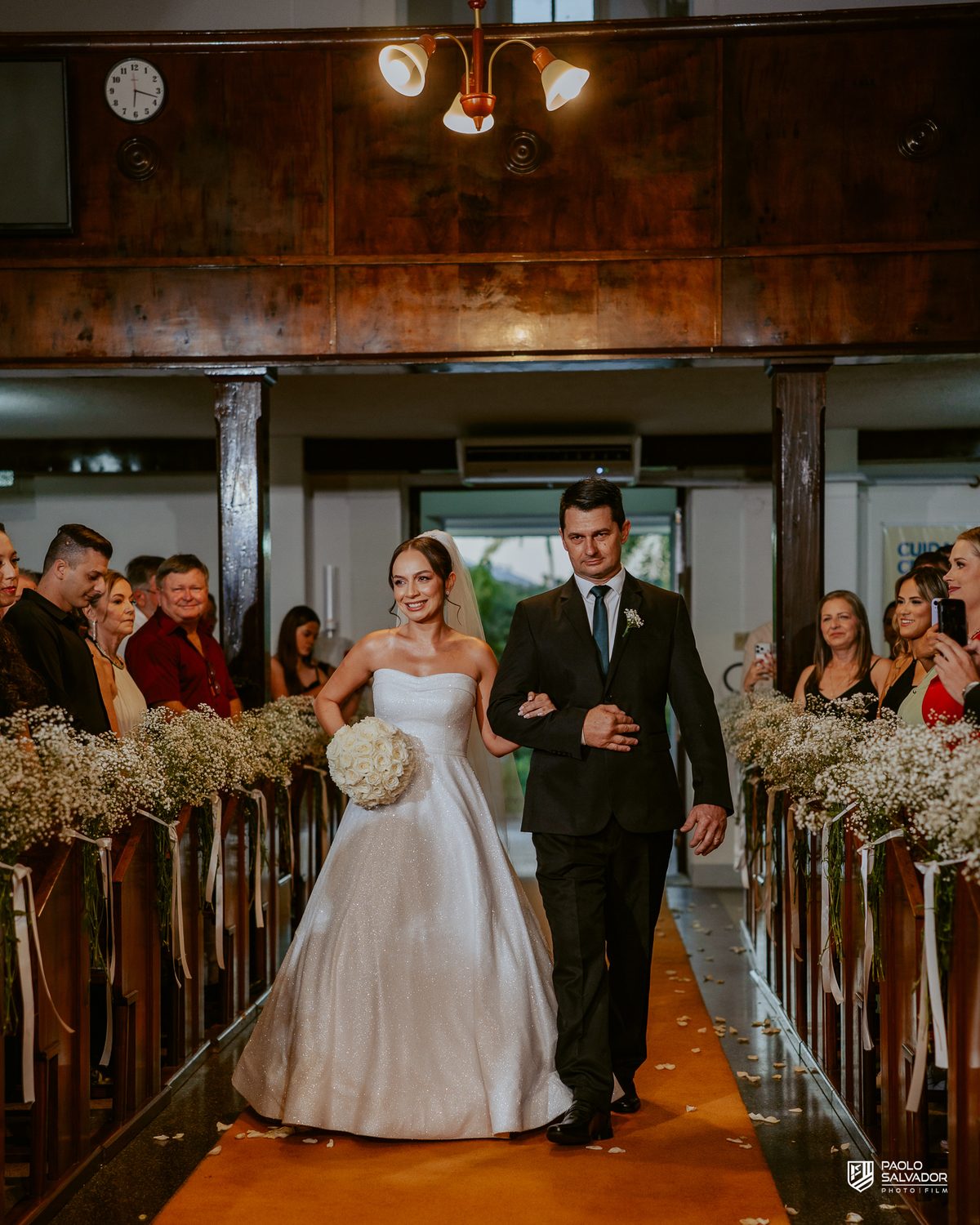 Casamento Jaque e Thayro em igreja de Massaranduba, entrada da noiva e emoção da cerimônia, fotografia de casamento clássica e documental, noivos no altar com convidados ao fundo