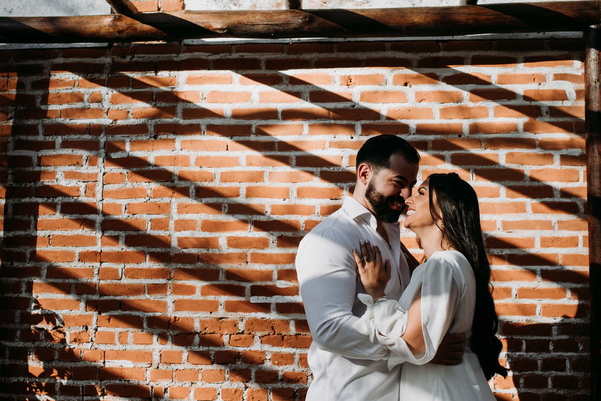 casal de noivos abraçado na sombra da parede em santo antónio do pinhal