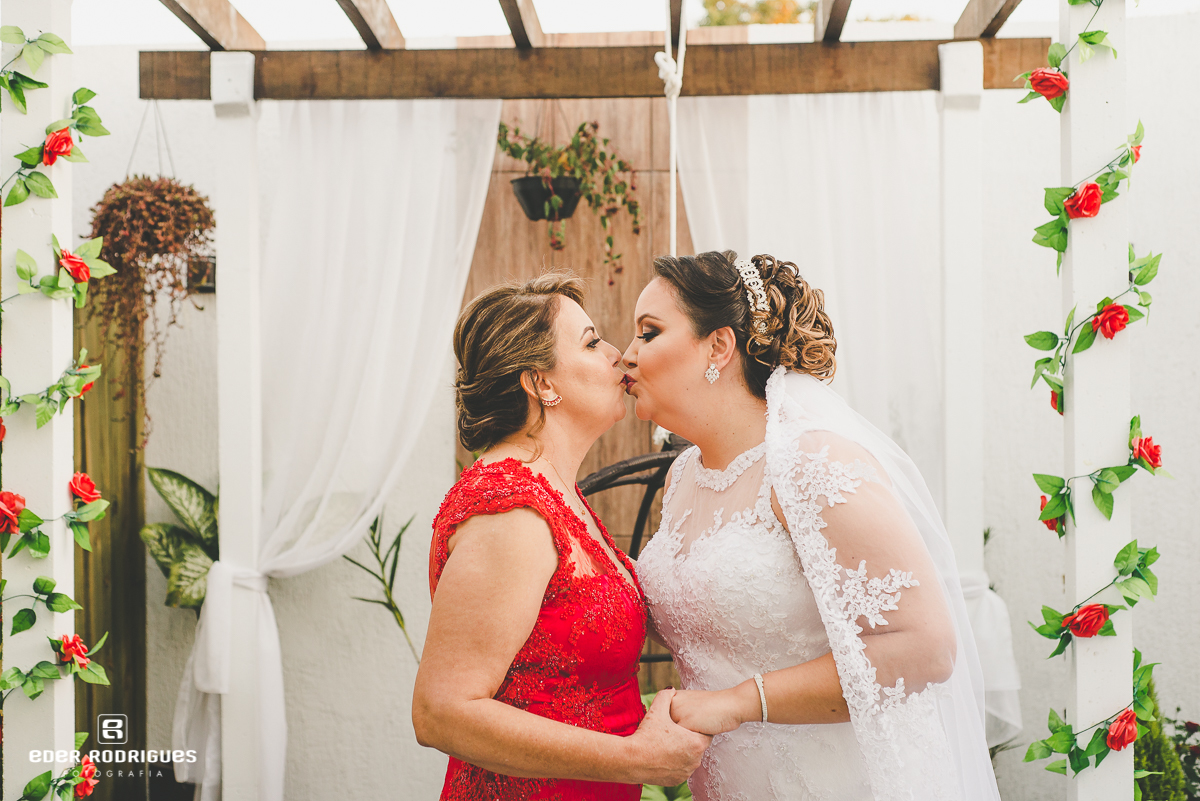 mãe beijando a noiva no salão
