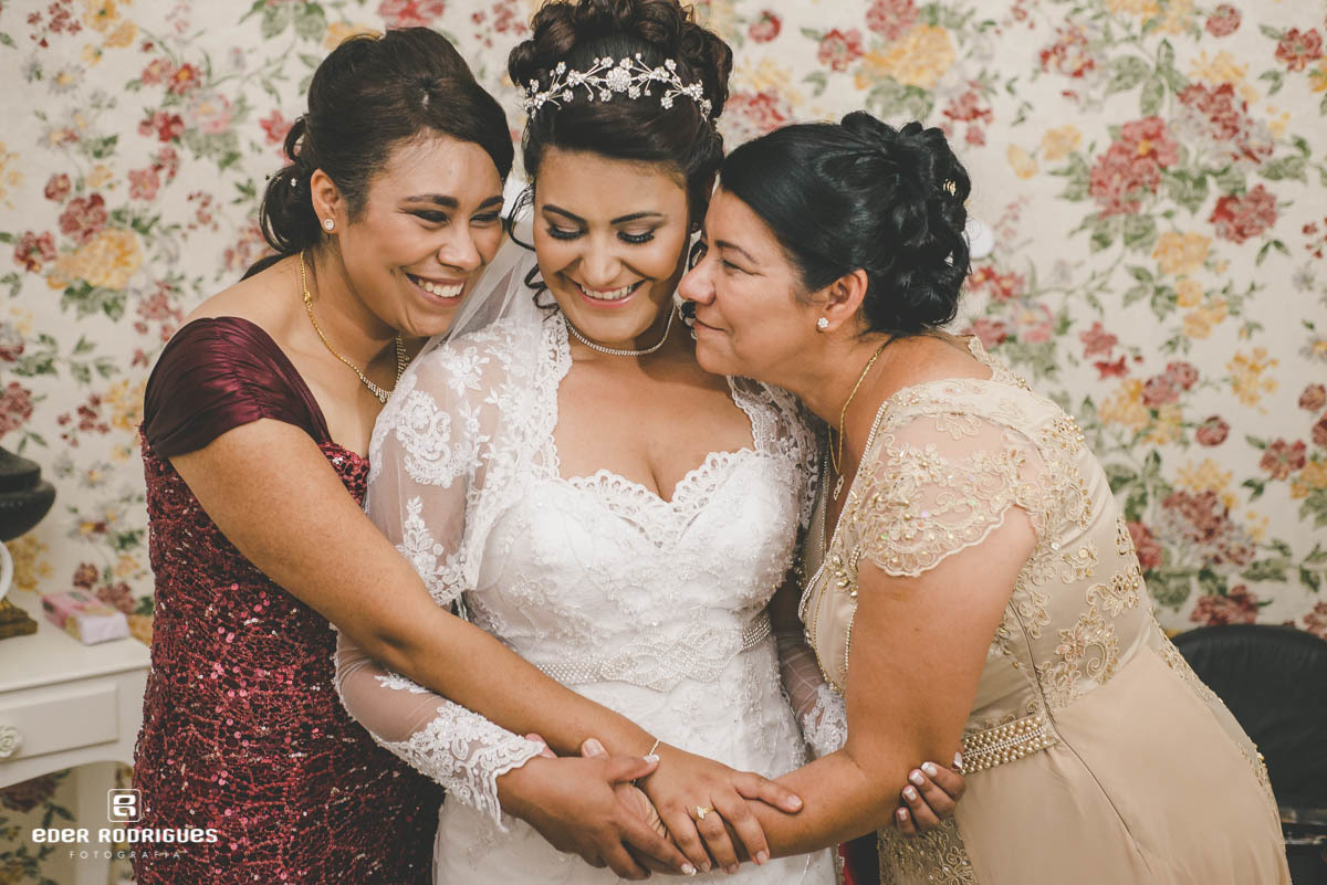 noiva sendo abraçada pela irmã e mãe