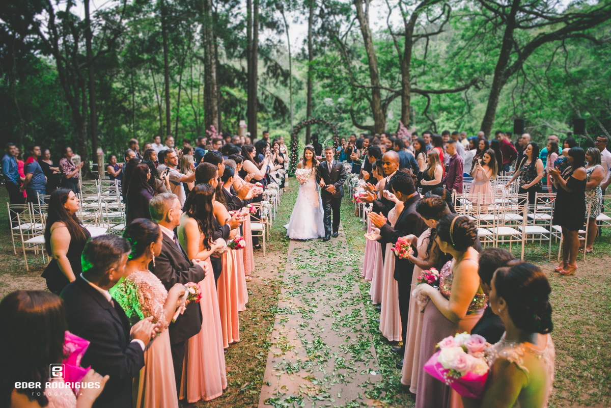 padrinhos jogando pétalas de rosa nos noivos