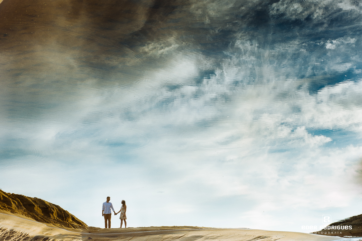 reflexo dos noivos na água na praia de prumirim