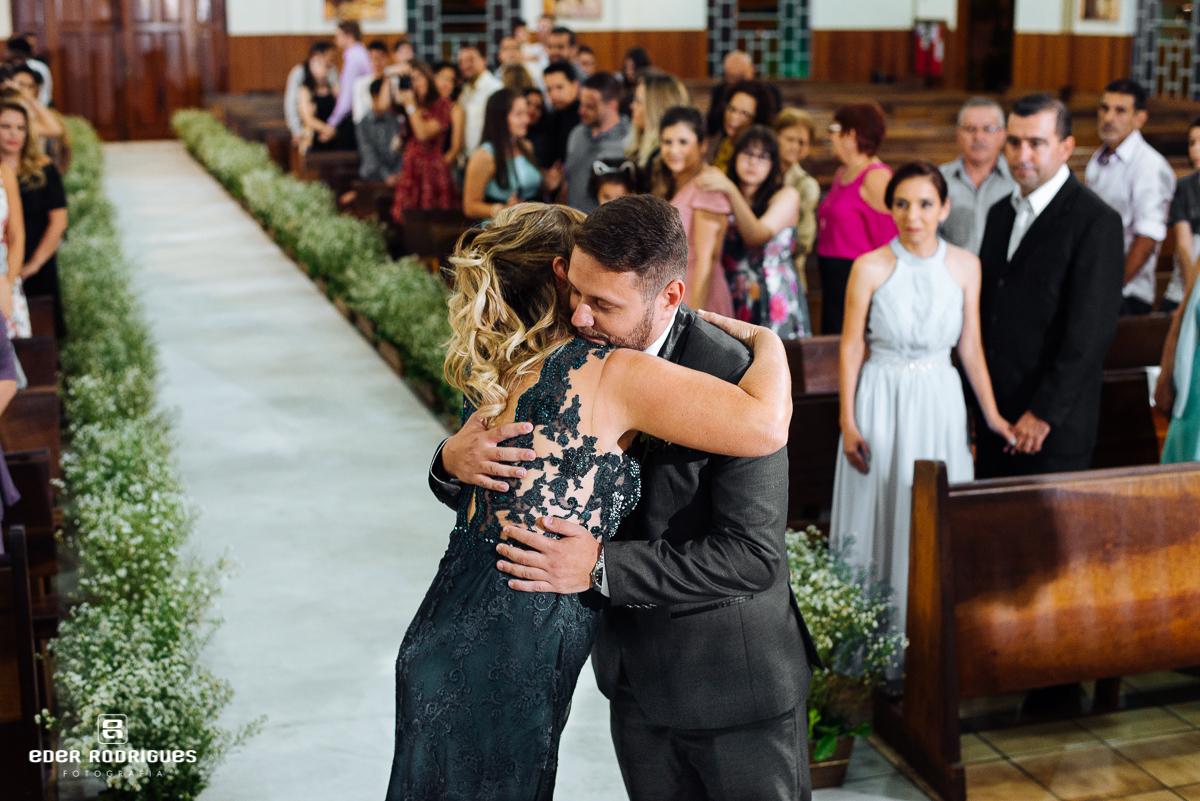 noivo abraçando  mãe na igreja sagrada familia sjc