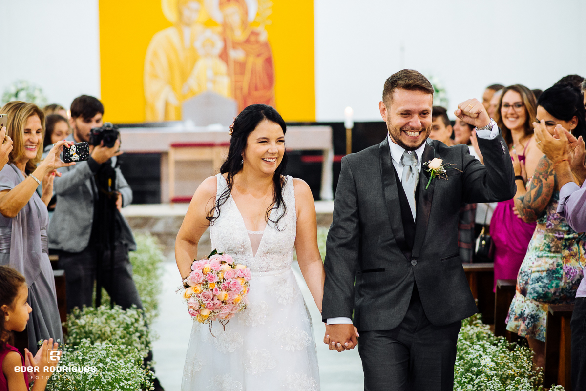 noivo comemorando o casamento na saida da igrejja