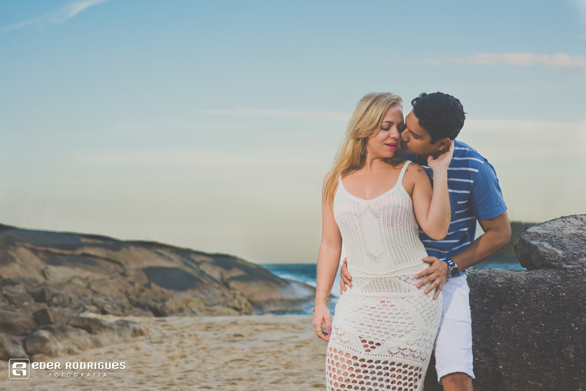 casal trocando carinhos sentado na pedra