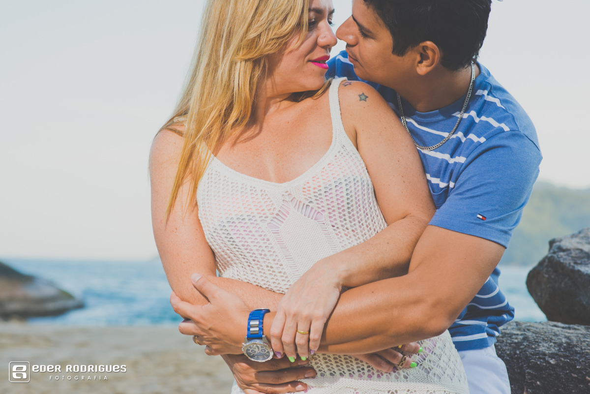 casal se abraçando na praia
