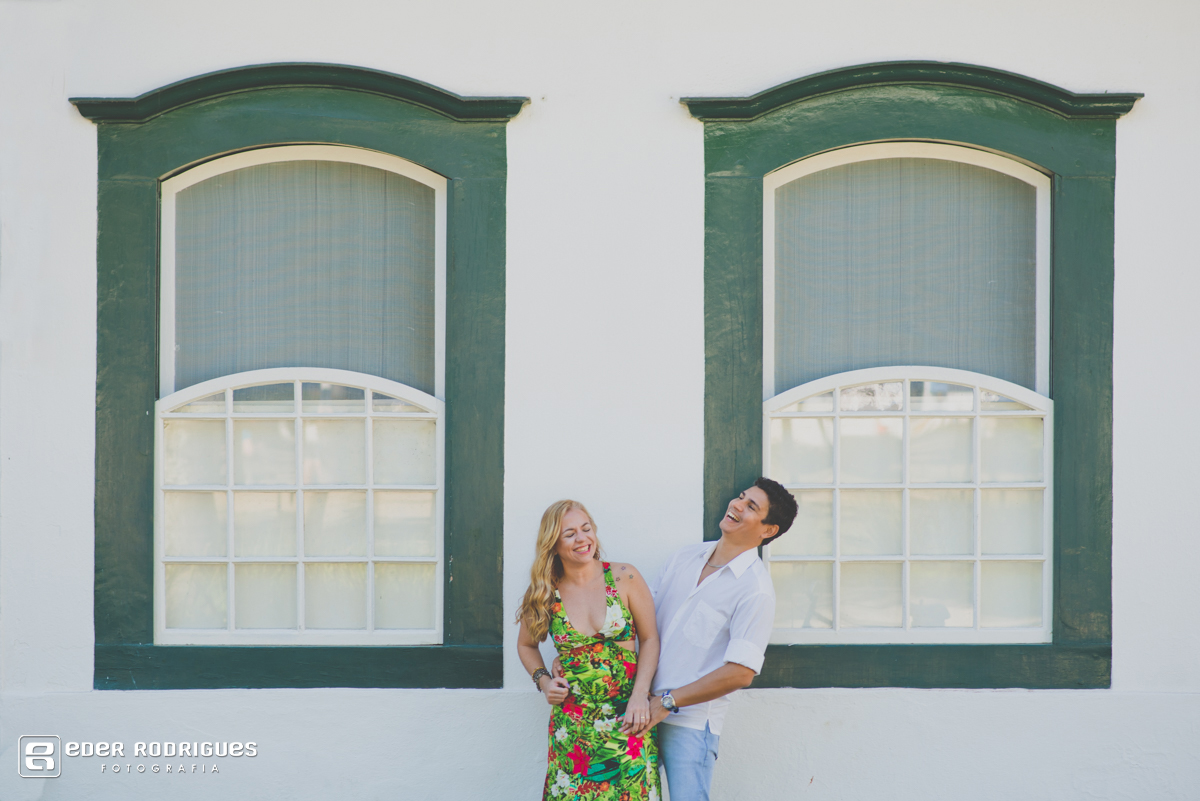 casal sorrindo na frente da janela