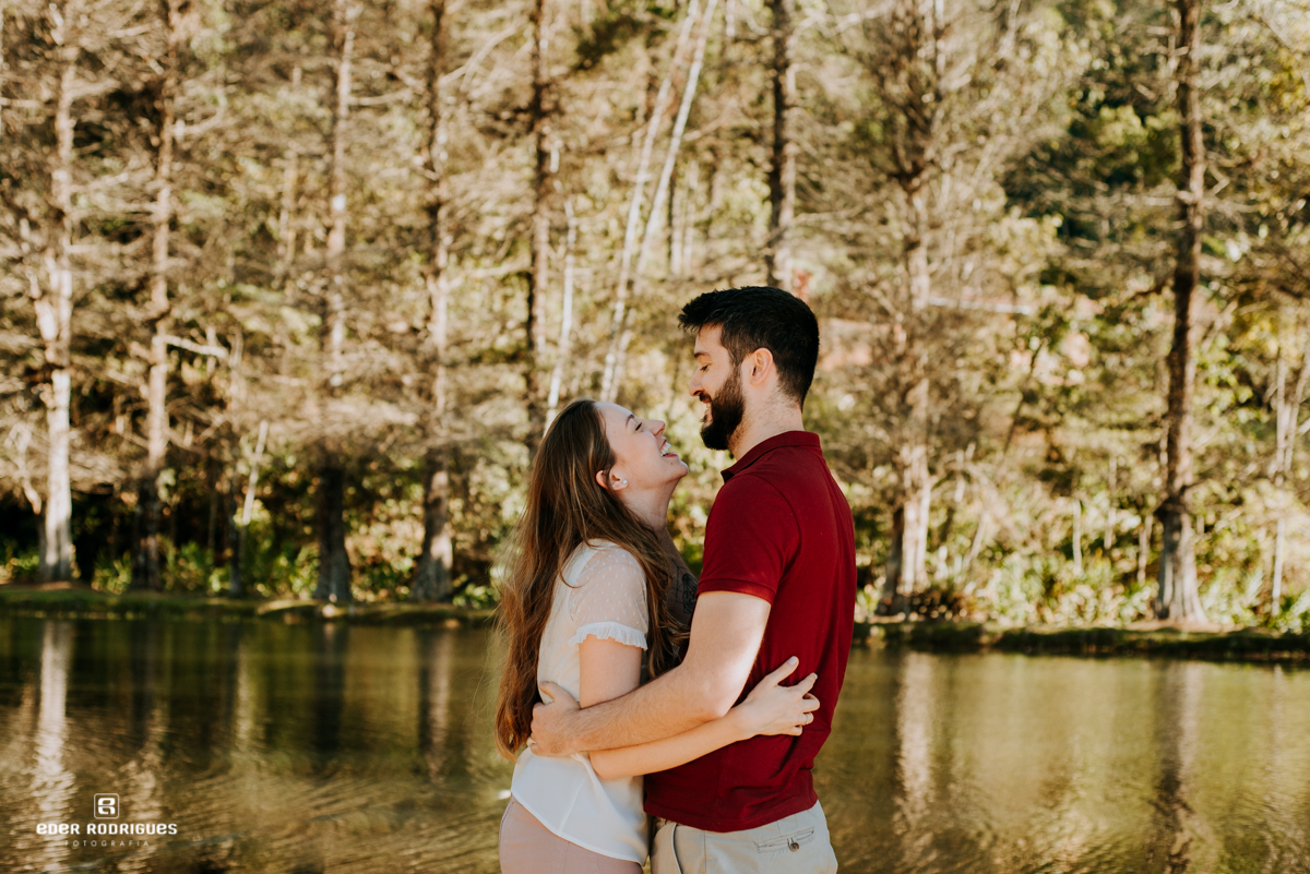 casal sorrindo na beira do lago