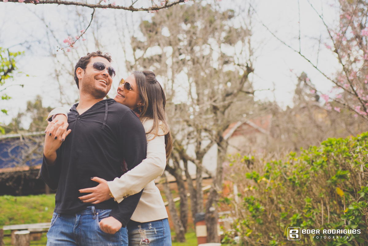 casal felizes entre as flores de cerejeiras em campos do jordão