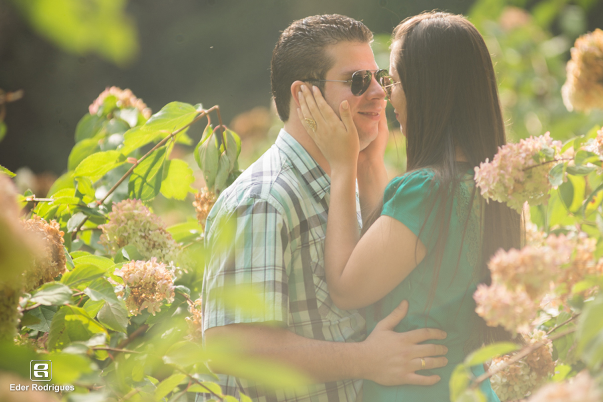 noiva fazendo carinho no noivo na plantação de flores