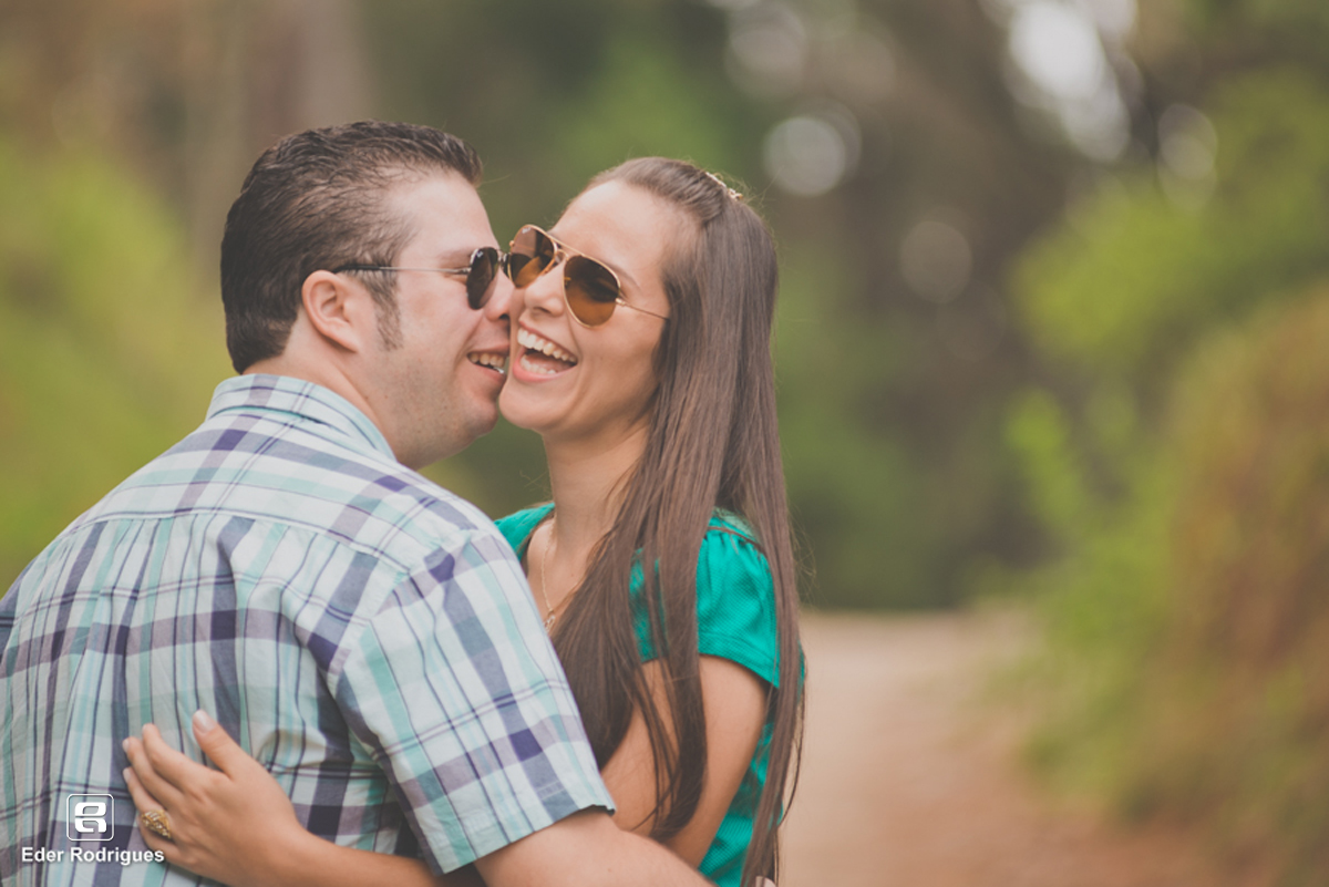 casal sorrindo e se abraçando no horto florestal