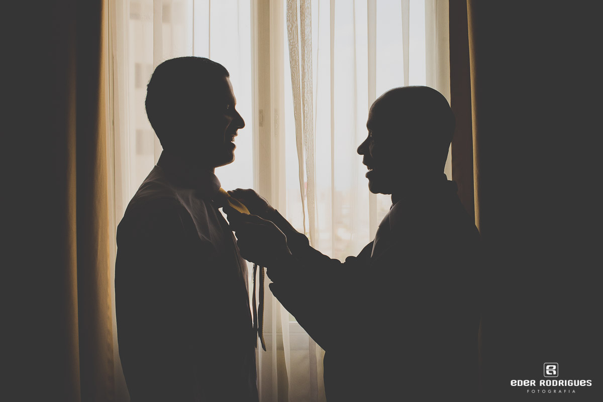 pai colocando a gravata no noivo