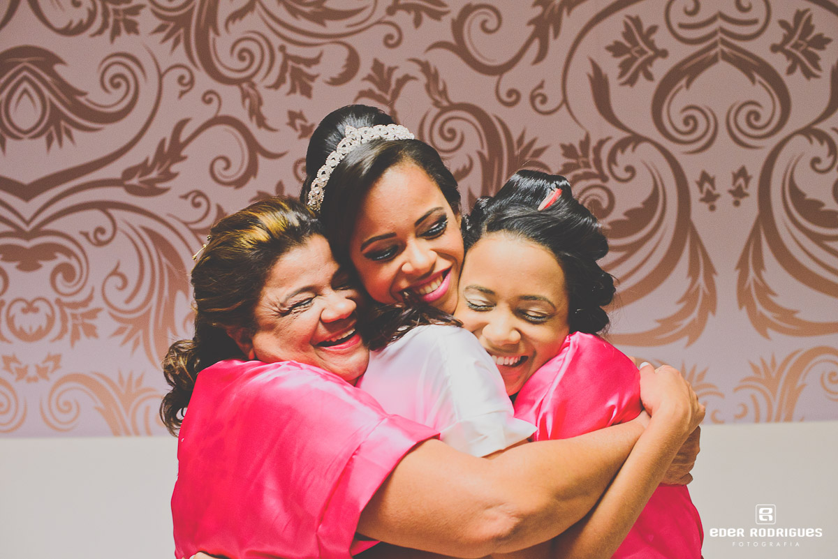 mãe e irmã abraçando a noiva no making