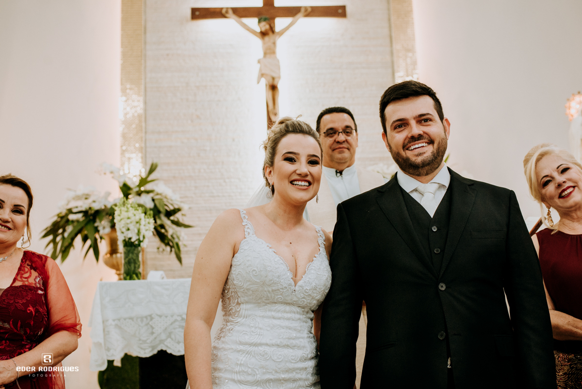 noivos sorrindo para daminhas na igreja em sjcampos