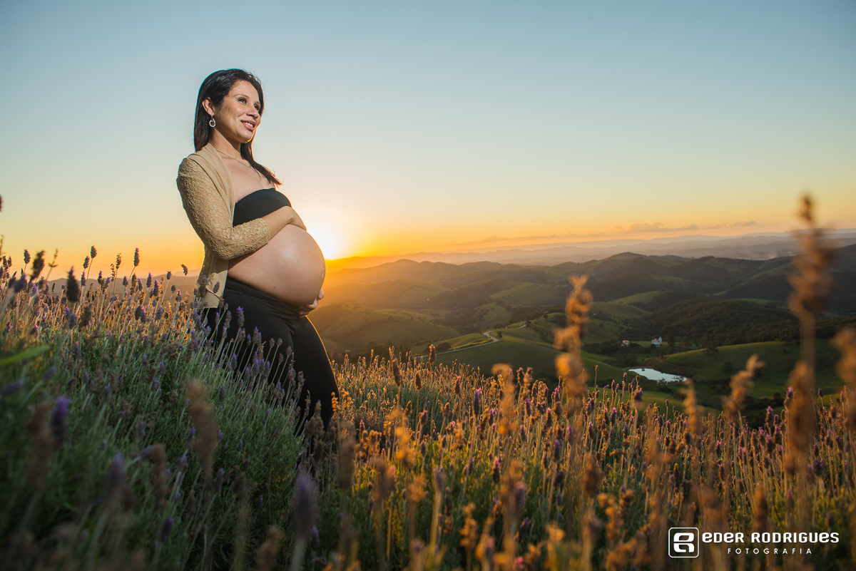 gravida feliz e sorrindo no pôr do sol