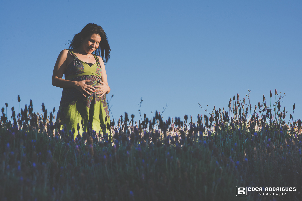 gravida sorrindo com a mão na barriga no lavandario