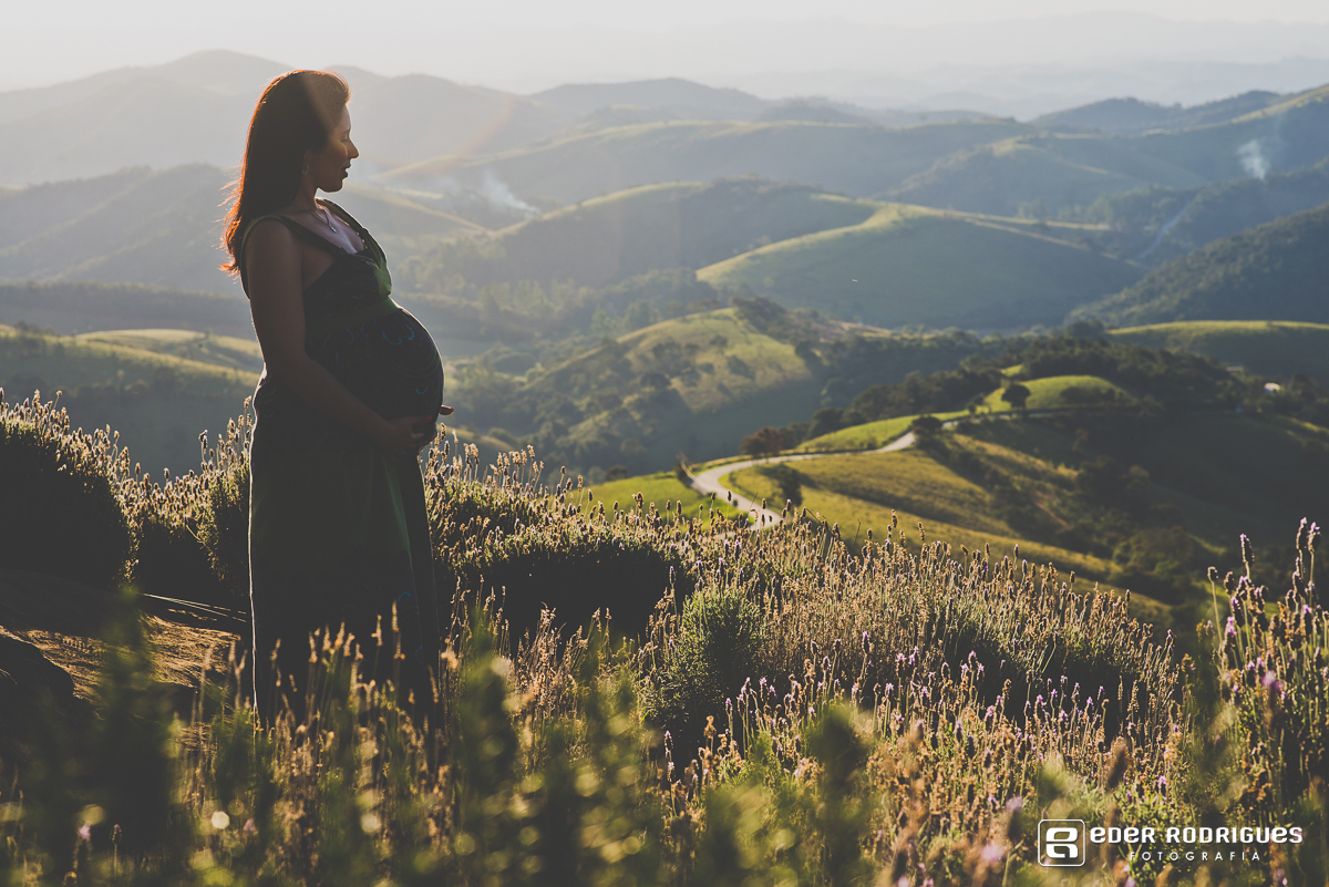 gravida sorrindo com a mão na barriga na lavanda