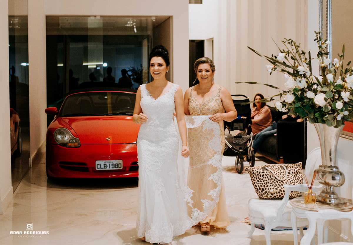 mãe da noiva carregando o vestido