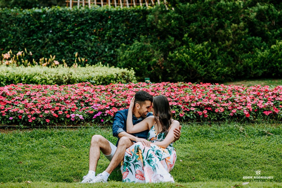 noivos sentados nas flores no parque jardins dos pinhais