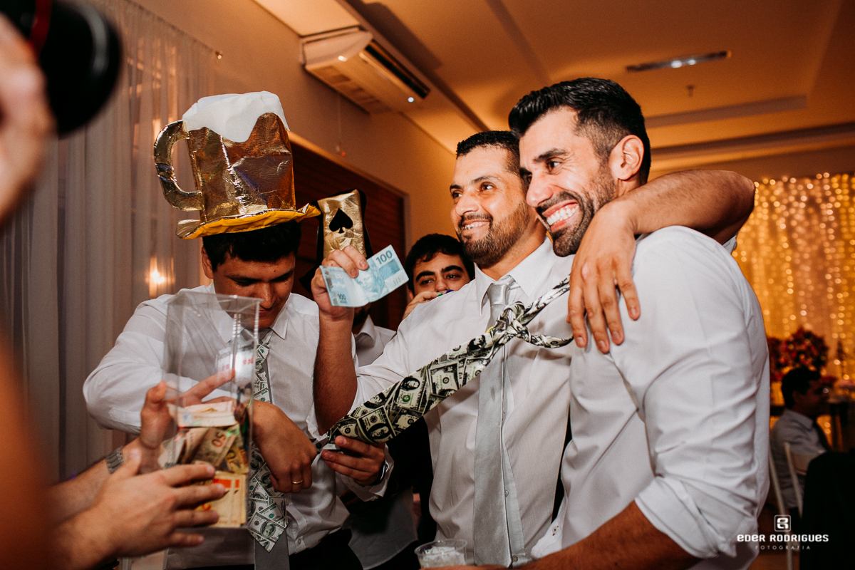 noivo cortando gravata com os padrinhos