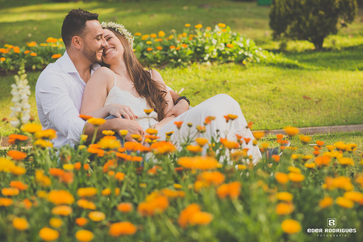 Casal de noivos dando risada em meio as flores, no Jardim dos Pinhais Ecco Parque