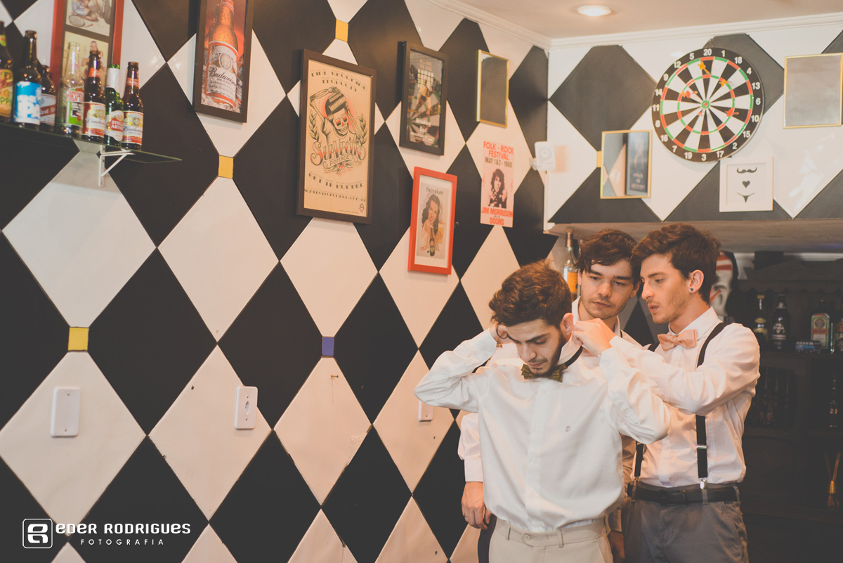 padrinhos ajudando noivo com a gravata no making of