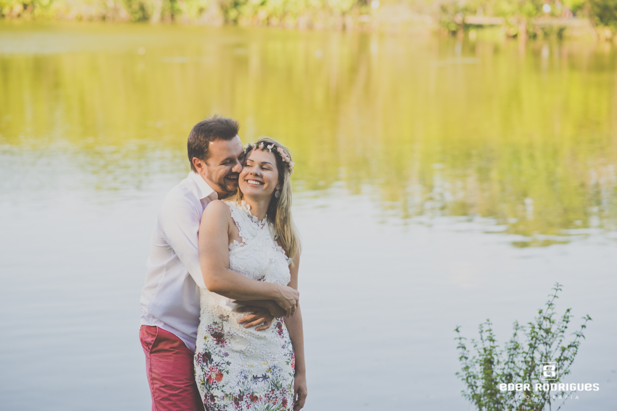 casal na beira do lago, noivo beijando a noiva no parque da cidade em São José dos Campos