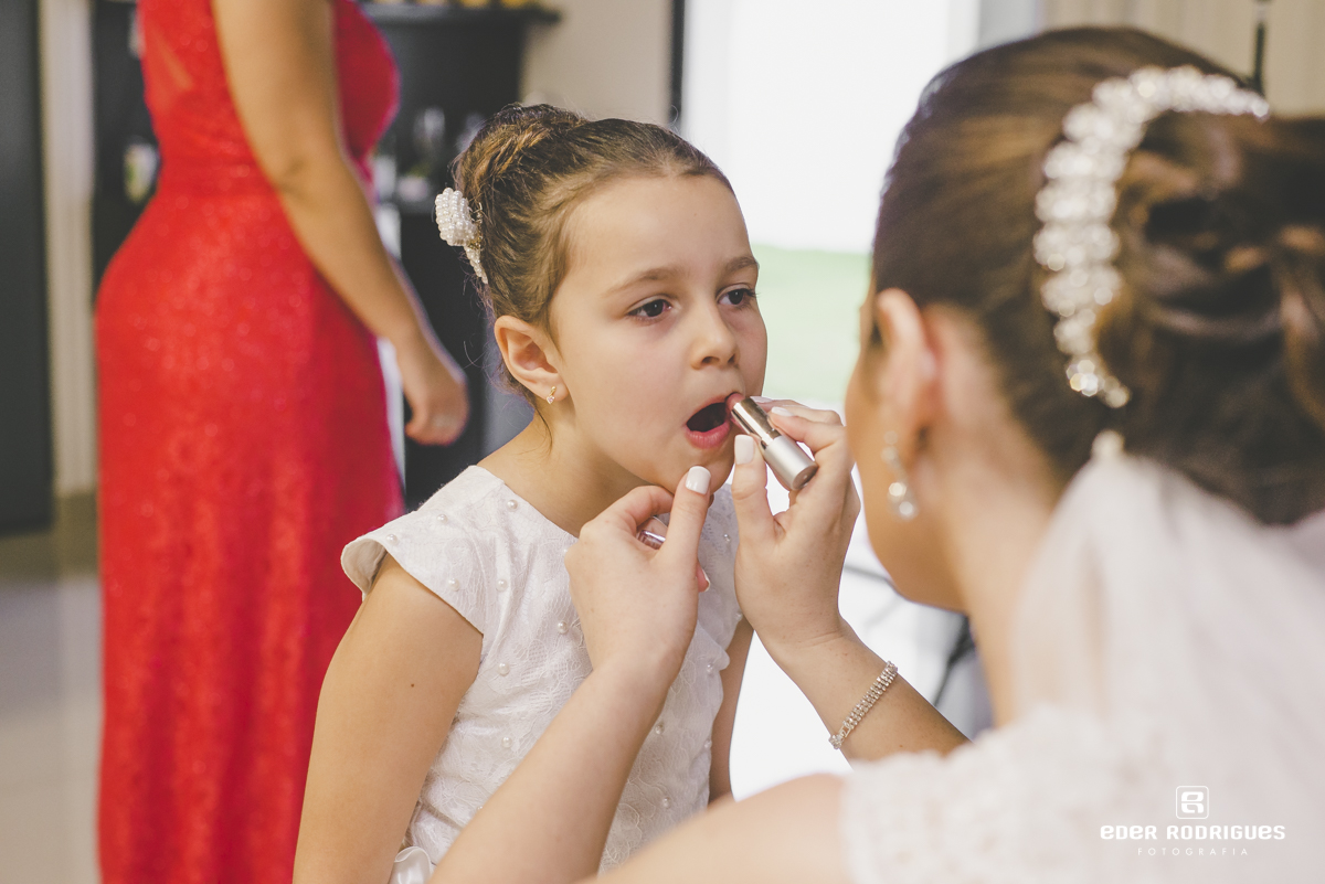 Noiva passando batom na daminha