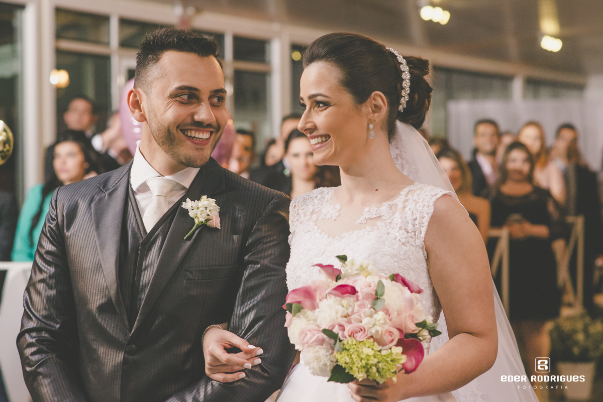 Casal de noivos se olhando e sorrindo