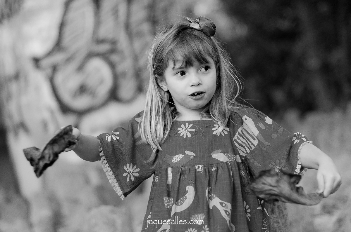 menina se diverte, canta e brinca com as folhas