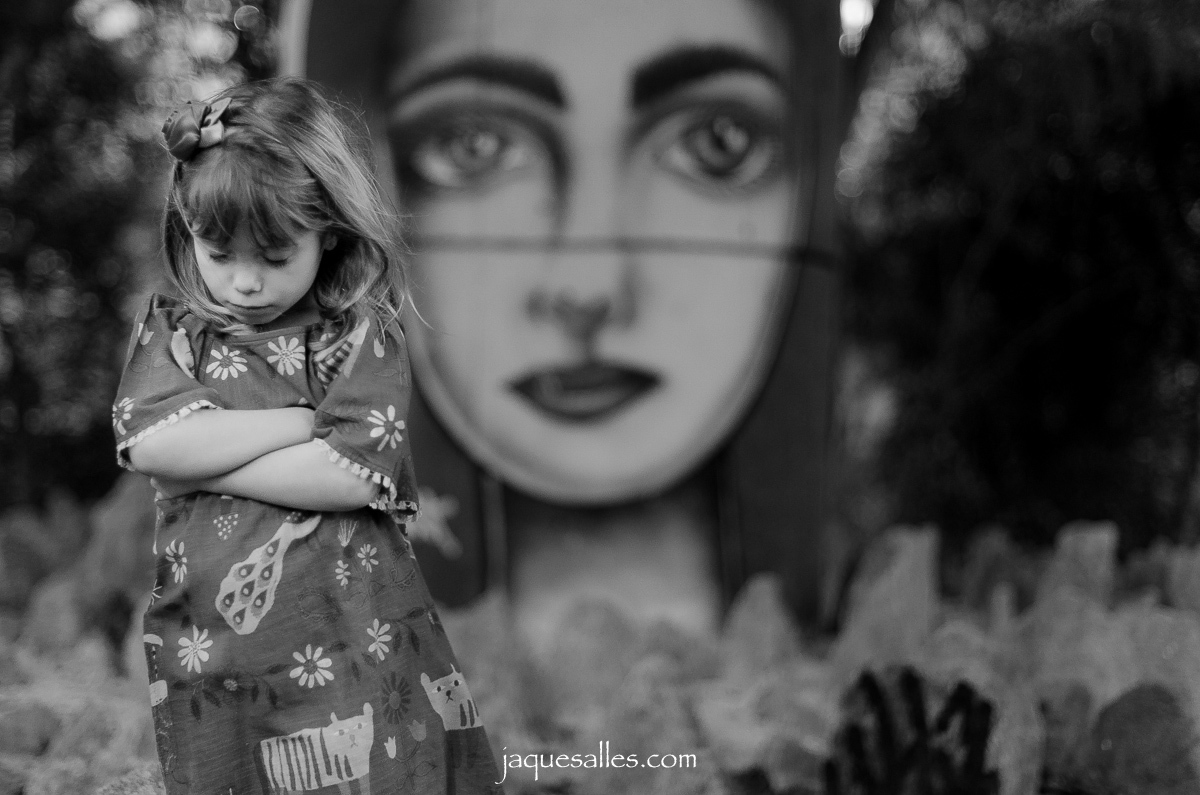 criança emburrada de braços cruzados