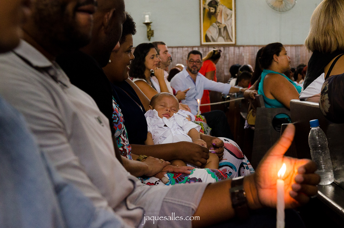 Bebê dorme enquanto aguarda ser batizado