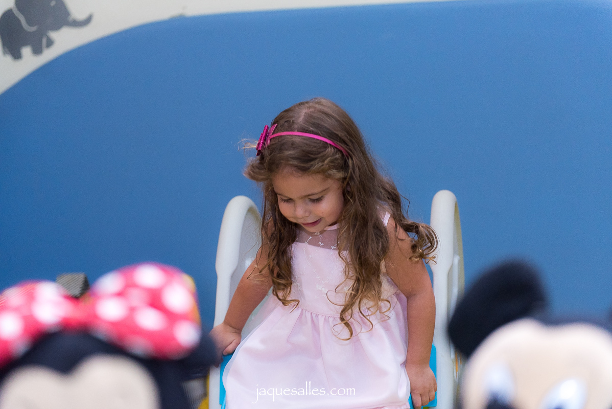 menina de rosa no escorregador infantil