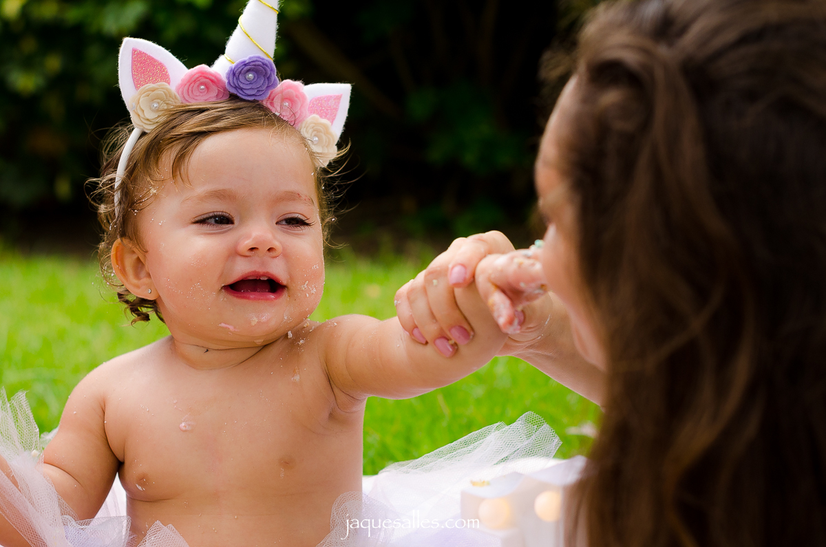 bebê da bolo de aniversário para a mãe comer