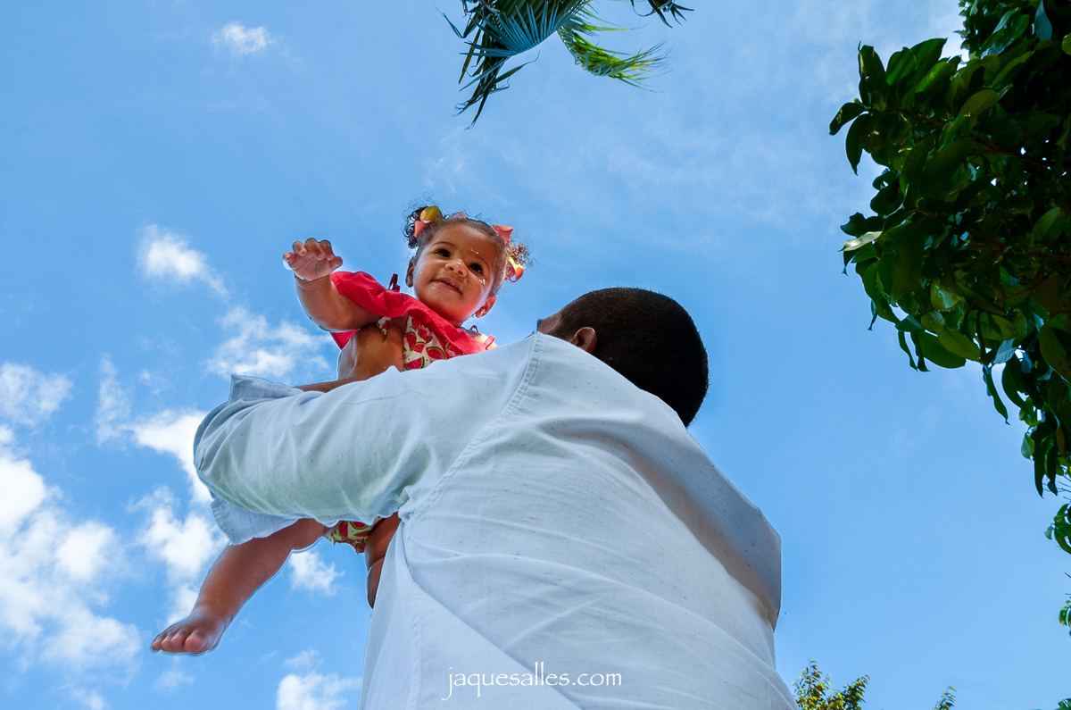 pai brincando com a filha no parque a joga para o alto
