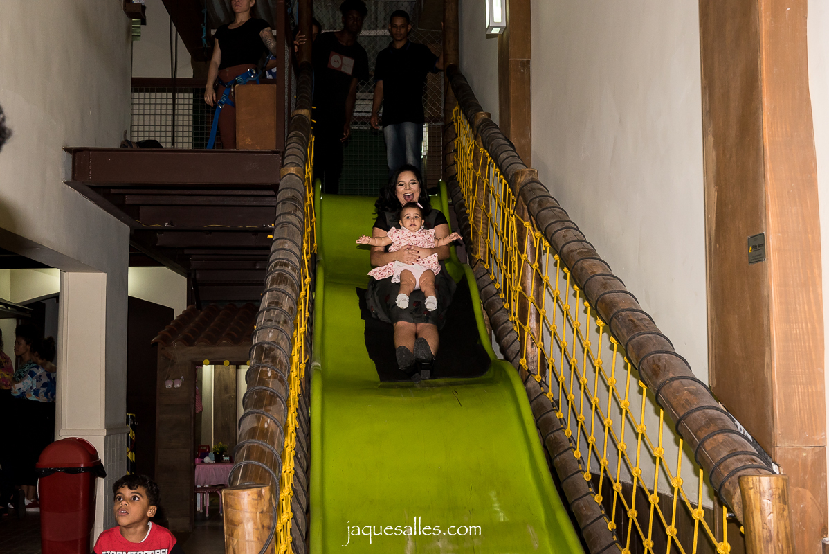 mãe brinca em escorrega na festa da filha de 1 ano