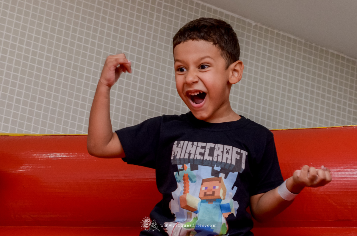 expressão de alegria de menino de 6 anos durante sua festa de aniversário com o tema minecraft