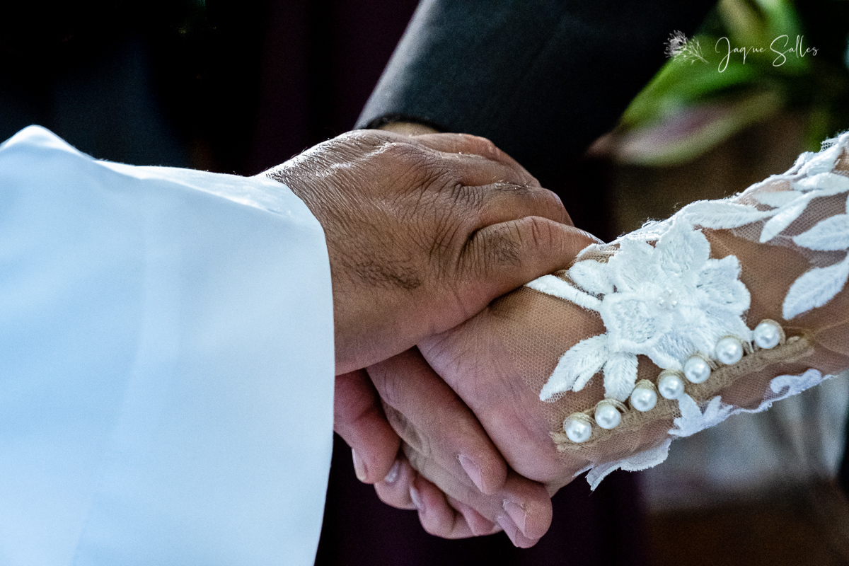 Padre abençoa no altar as alianças dos noivos Priscila e Cadu na Igreja de Santa Thereza D’ávila em Rio das Flores - RJ. Imagens da Fotógrafa de Casamento Jaque Salles Fotografia