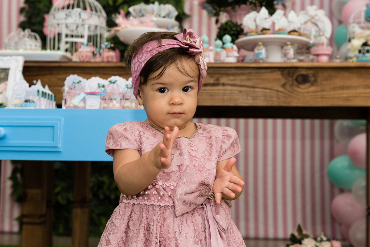 menina bate palma em frente a decoração da sua festa