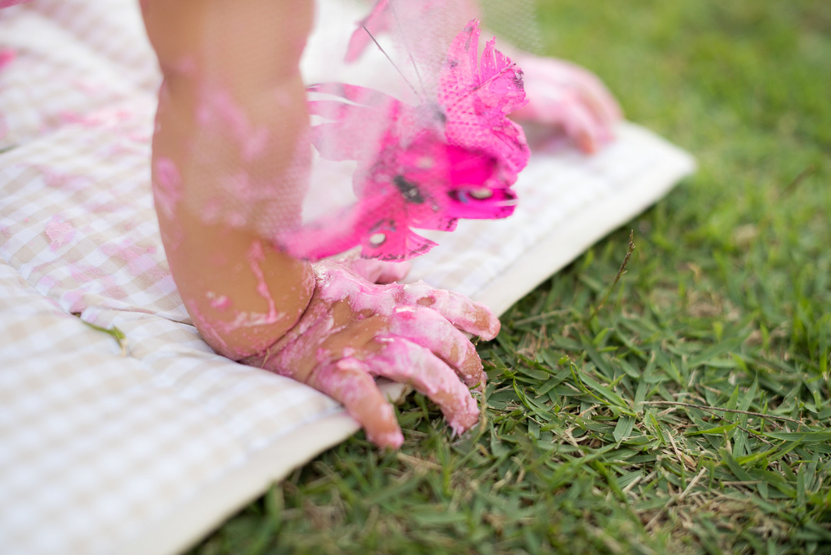 detalhes da mão suja de bolo da bebê Isadora
