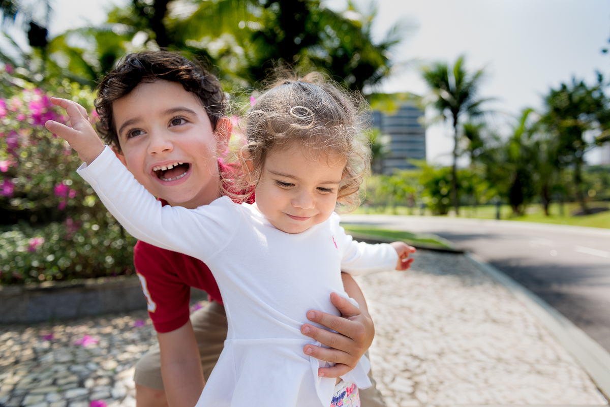 Irmãos que se amam brincam no jardim do condomínio durante fotos de família