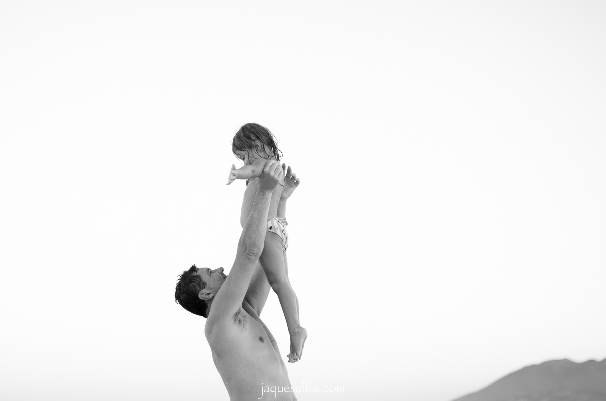 Pai levanta a filha durante ensaio fotográfico de família na praia do forte  em cabo frio