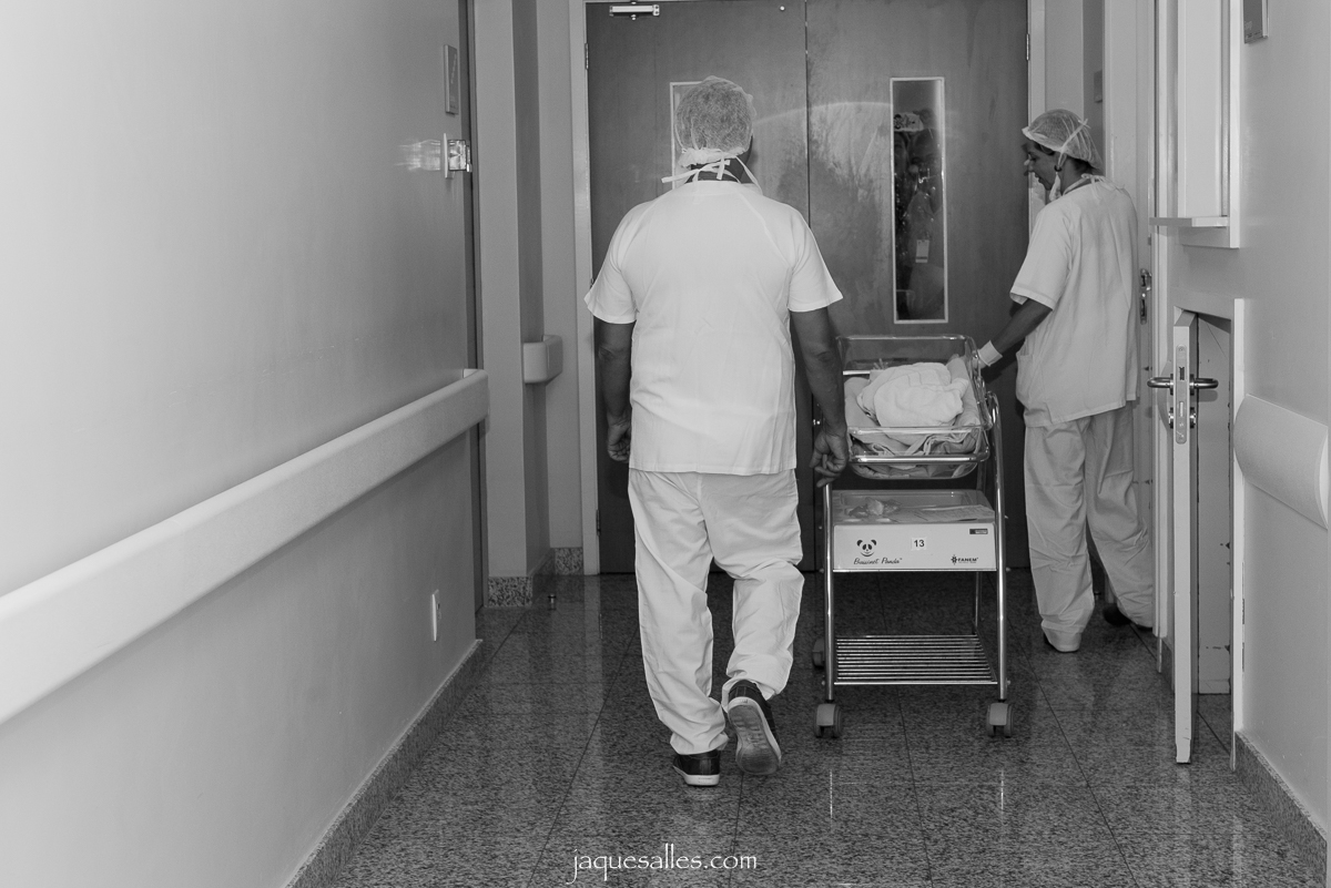 pai acompanha o seu bebê pelos corredores da maternidade perinatal para receber os primeiros cuidados no berçário