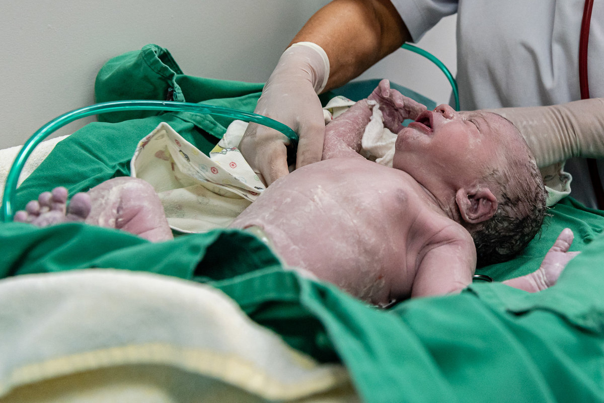 Primeiros cuidados da pediatra com o bebê depois que ele nasce. Fotografia do parto do Gustavo realizado na maternidade Perinatal da Barra da Tijuca.  Imagens da fotógrafa de casamento e famílias Jaque Salles 